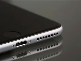 Macro close-up shot of a modern smartphone bottom speaker grill highlighting the tiny hardware driver.
