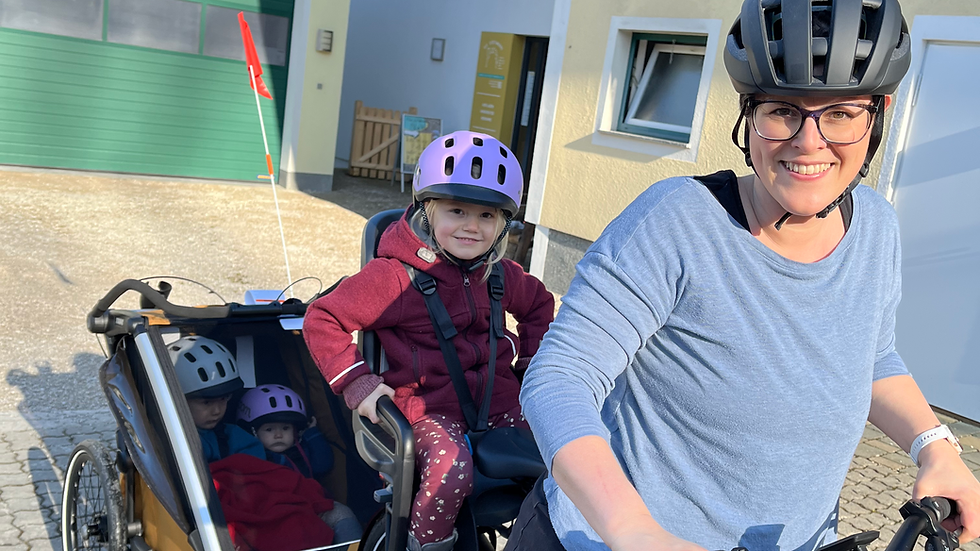 Stefanie mit Frieda im Fahrradkindersitz Thule RideAlong2 und Frieda und Xaver im Fahrradanhänger thule Chariot Sport 2 Double