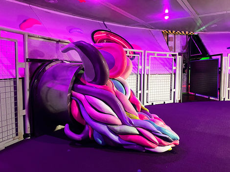 A tendril sculpture flowing out of one of the Omega Mart factory tubes