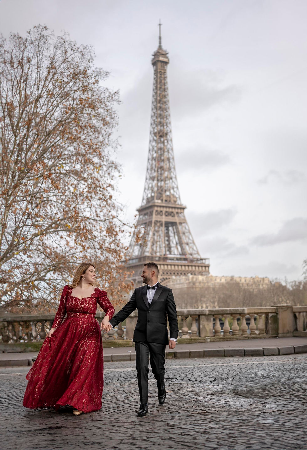 Professional Paris photographer capturing a couple at the Eiffel Tower during sunrise, reflecting the personalized, high-quality experience of direct booking.