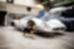 PHOTO D’UN CHIEN COURANT DEVANT LA CARCASSE D’UNE VIEILLE VOITURE