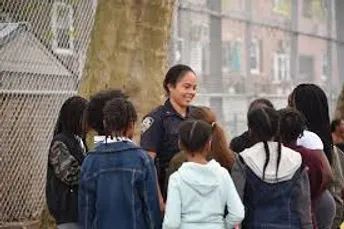 Female New York City Cop talking to a group of children