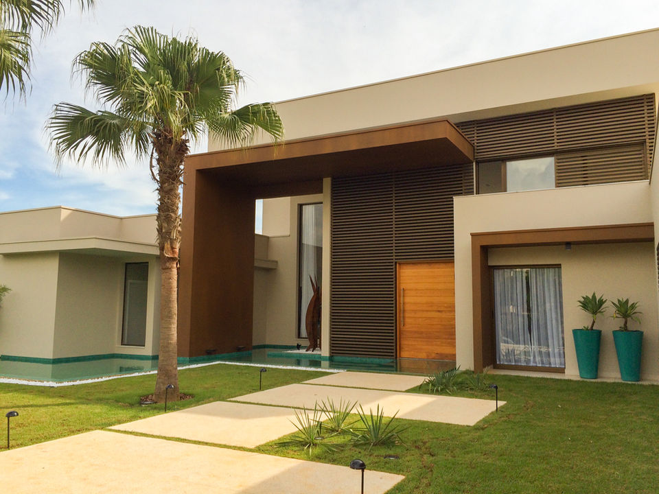 Fachada de residência moderna com pintura efeito aço corten Revlux Tintas, projeto de design e paisagismo por Helena Montevecchio. Elegância e sofisticação em arquitetura contemporânea.