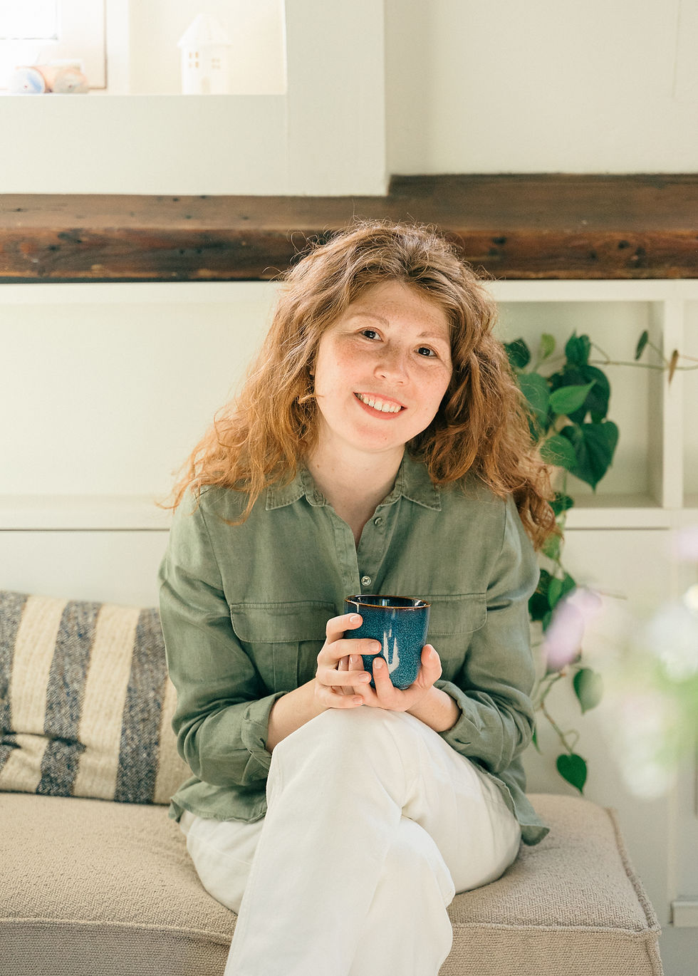 Julia smiling out of a picture with a coffee cup in her hand