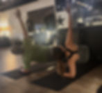 Participants engage in a focused barre class, performing side planks to enhance core strength and stability.