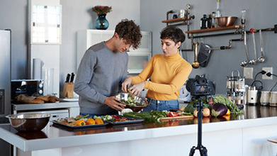 Man and woman cooking in front of a camera