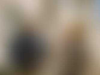 Engenheiro e arquiteta realizam inspeção técnica a edifício em Lisboa, analisando fachadas e tomando notas em tablets sob luz natural.