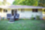 Yellow ranch house with side porch deck and two sliding glass doors