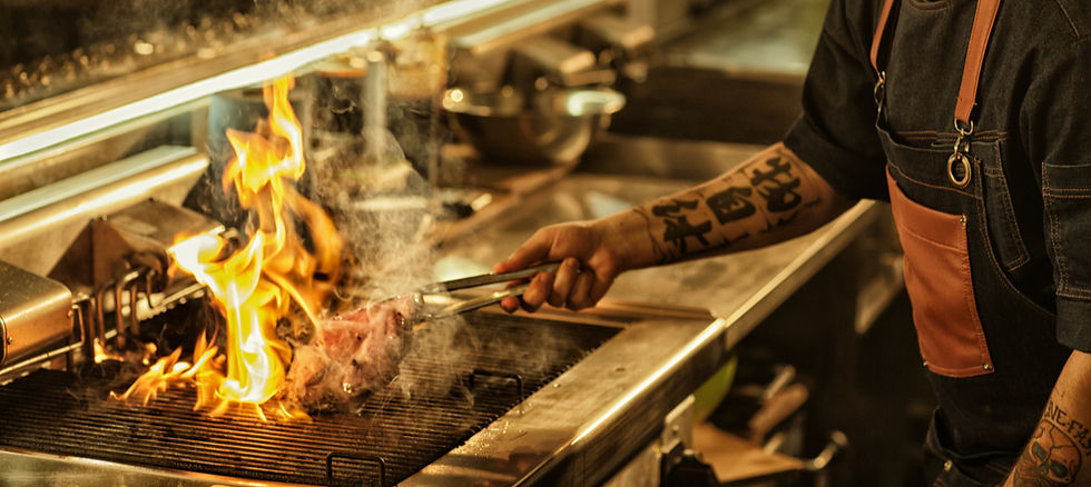 homme qui fait cuire de la viande sur un grill enflammé