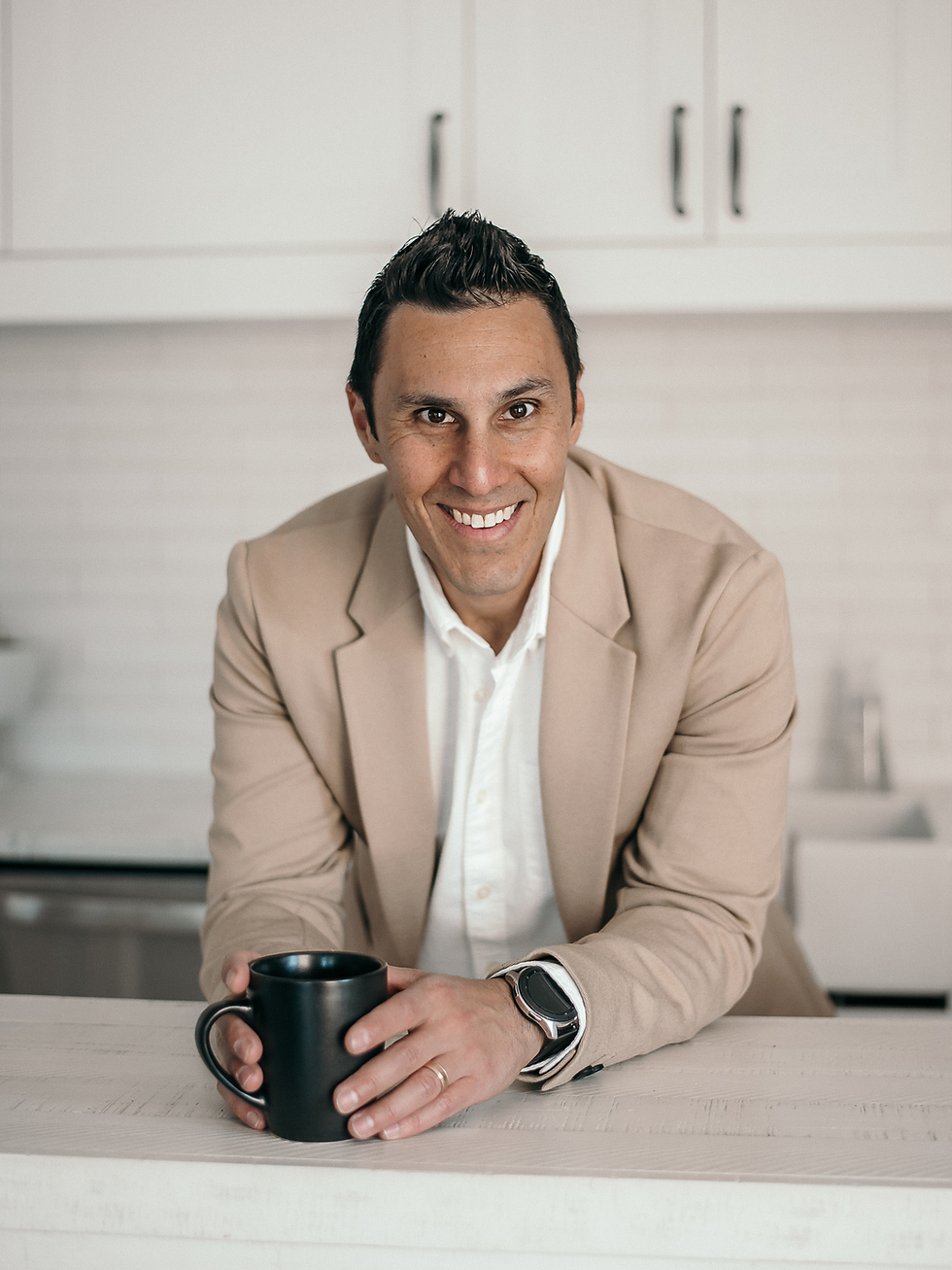 David holding a mug in the kitchen, casual and approachable with a warm expression.