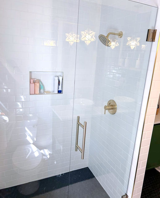 Modern glass shower, gold fixtures, and white tile. A luxury Briarcliff Bathroom design.