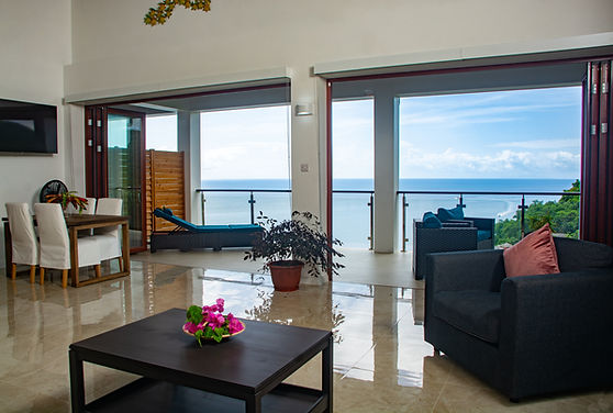 Deluxe Suite Merlot features Caribbean wood ceilings, sea views, and a wraparound balcony, perfect for birdwatching and relaxation.