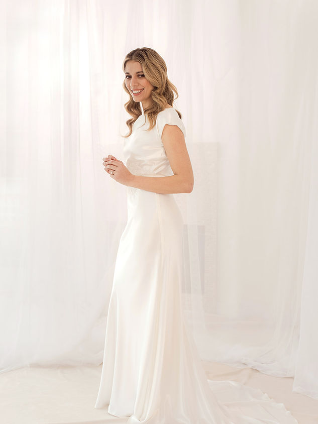 Harlow is a silk satin crepe bias cut dress with asymmetrical neckline.   It has buttoned back and lace appliqué around waistband.