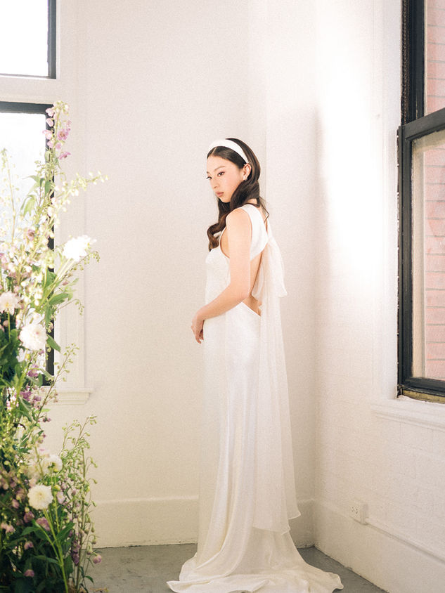 This boatneck bias cut dress is made with silk satin crepe, cutout back detail with chiffon tie. 