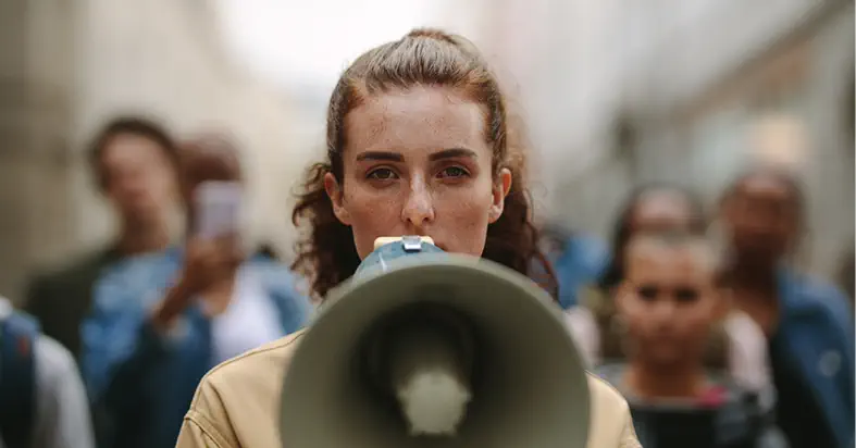 une femme avec un megaphone fait entendre sa voix lors d un rassemblement citoyen