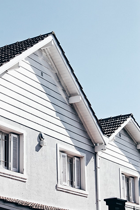 Side view of residential rooftops highlighting home structure and roofing.