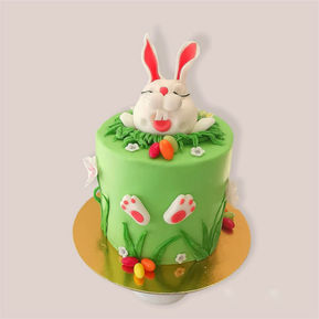 Buttercremetorte mit diversen Dekoelemnten aus Fondant, modellierter Osterhase als Cake Topper