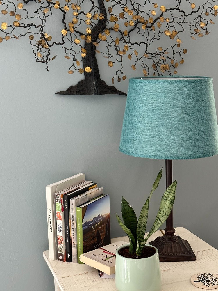 Side table with books, a lamp, and a plant.