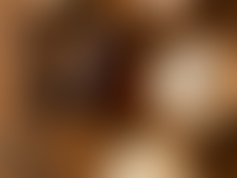 Flat-lay of vanilla beans, a bottle of vanilla extract, eggs, flour, sugar, and a whisk on a wooden table illustrating the real ingredients in vanilla extract.