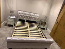 double bed with two glass bedside tables in a bedroom