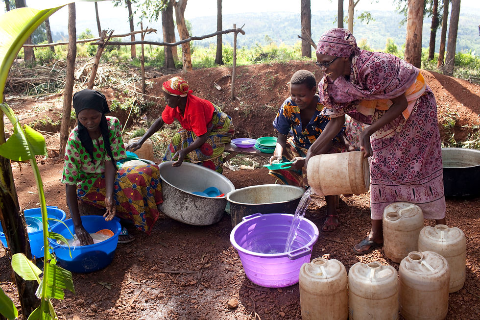 People cooking on the ground, pouring water and making food.