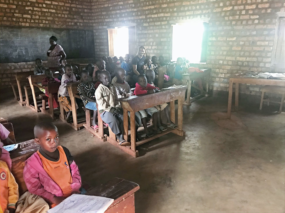 Children sitting at desks in a dark classroom with brick walls