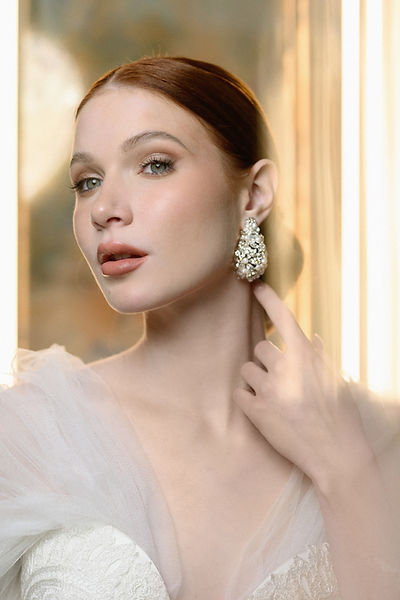 Bold and radiant statement earrings, crafted with sparkling silver-hued crystals, delicately intertwined with glass beads, luminous pearls, and brilliant Swarovski stones.