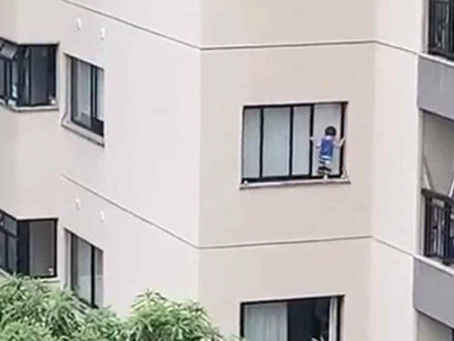 Criança é flagrada pendurada em janela de prédio; veja vídeo