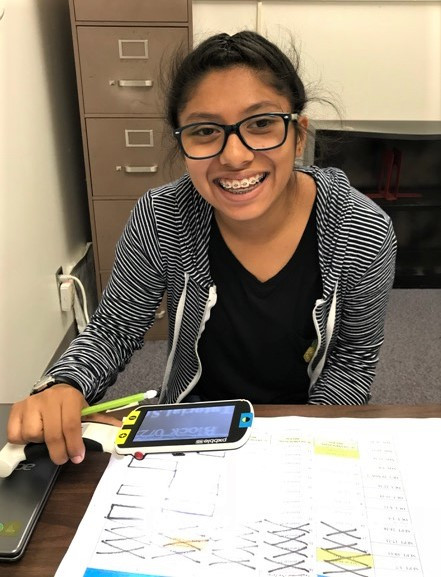 Rosa using a portable video magnifier to do classwork