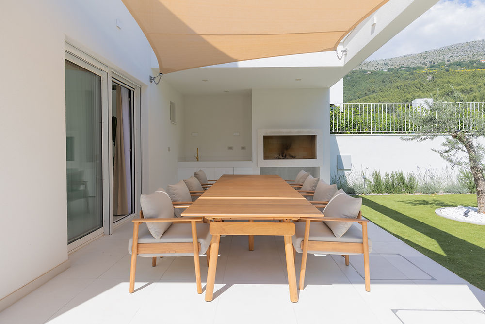 Modern outdoor kitchen and dining patio at Villa C