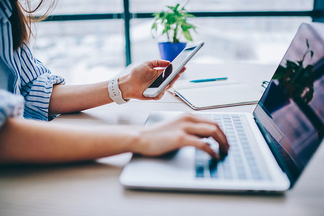 Marketing employee working on their laptop and phone