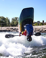 Freestyle kayaker training on whitewater in Millau