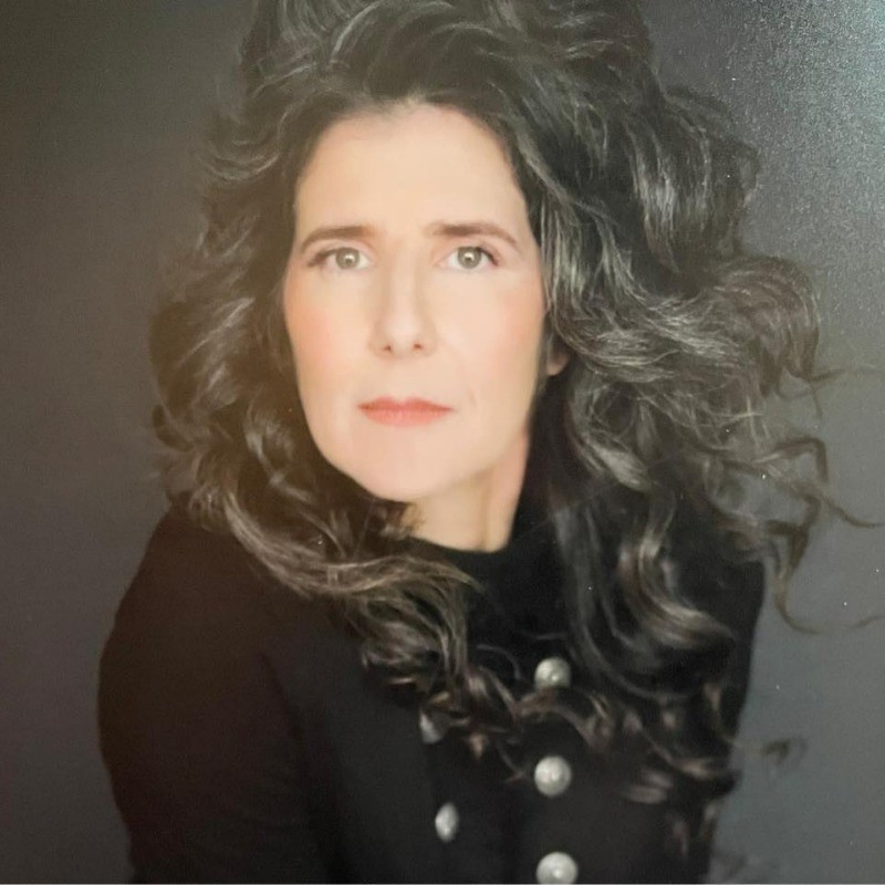 Portrait of a Jennifer Moeller, Founder of Mrs. Mekler's Mercantile with long, voluminous wavy dark hair.