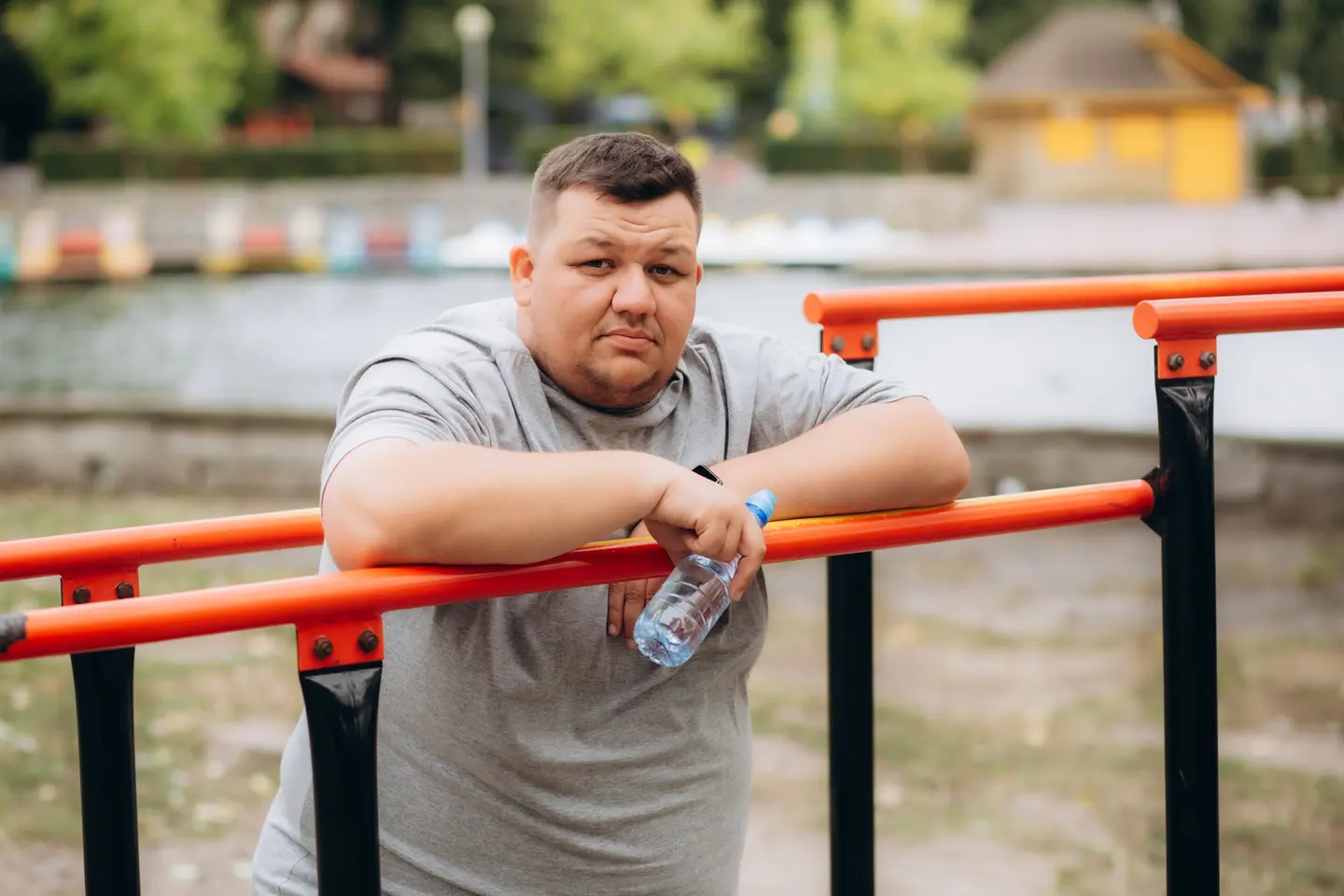Man resting on parallel bars outdoors