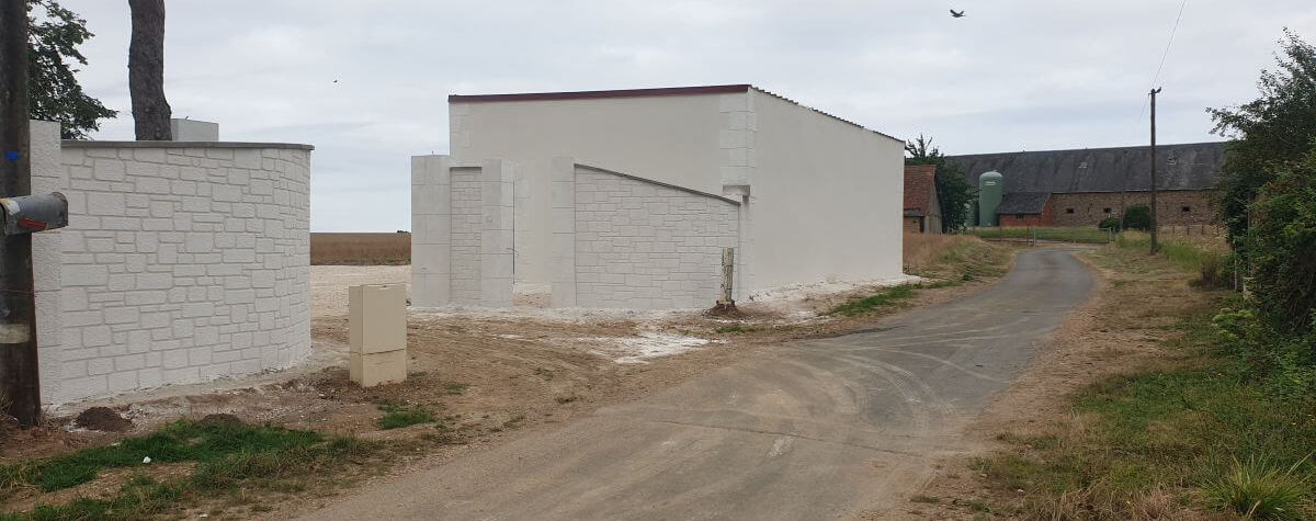Réalisation GDS Construction dans le 78 : muret courbe ravalé en blanc bordant un chemin d'accès privé, maçonnerie paysagère moderne dans les Yvelines.