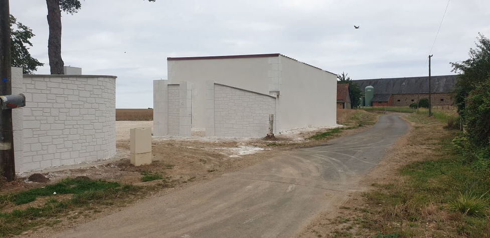 Réalisation GDS Construction dans le 78 : muret courbe ravalé en blanc bordant un chemin d'accès privé, maçonnerie paysagère moderne dans les Yvelines.