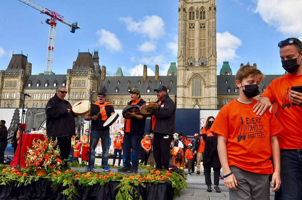 four Indigenous drummers sing in front of Parliament Hill on the National Day for Truth and Reconciliation