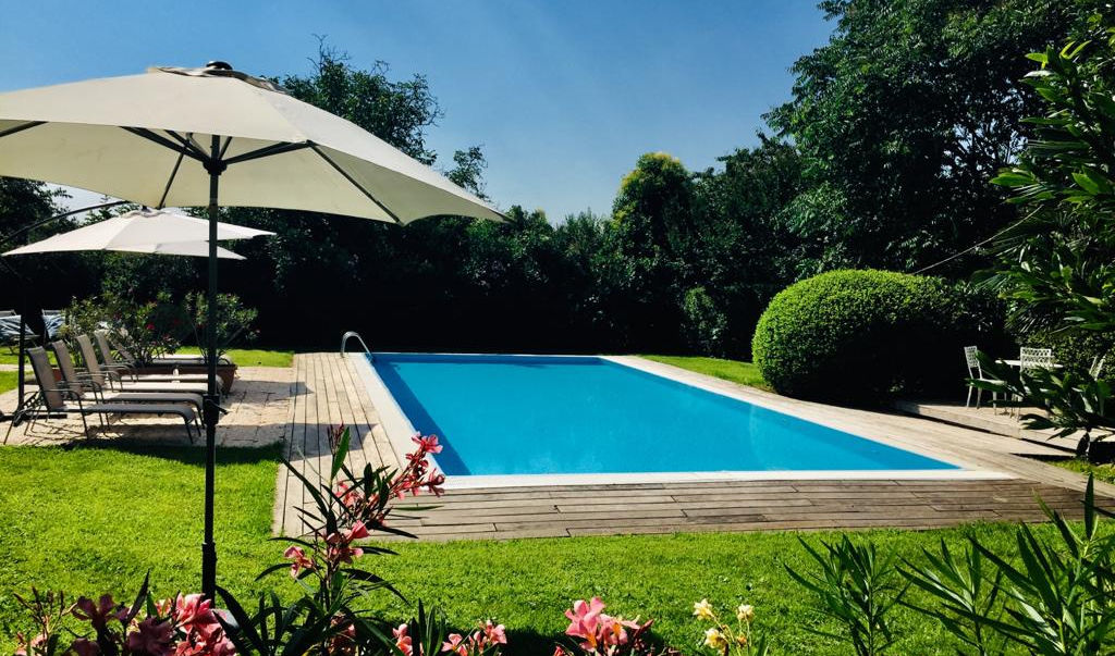 Piscina rilassante con ombrelloni, giardino