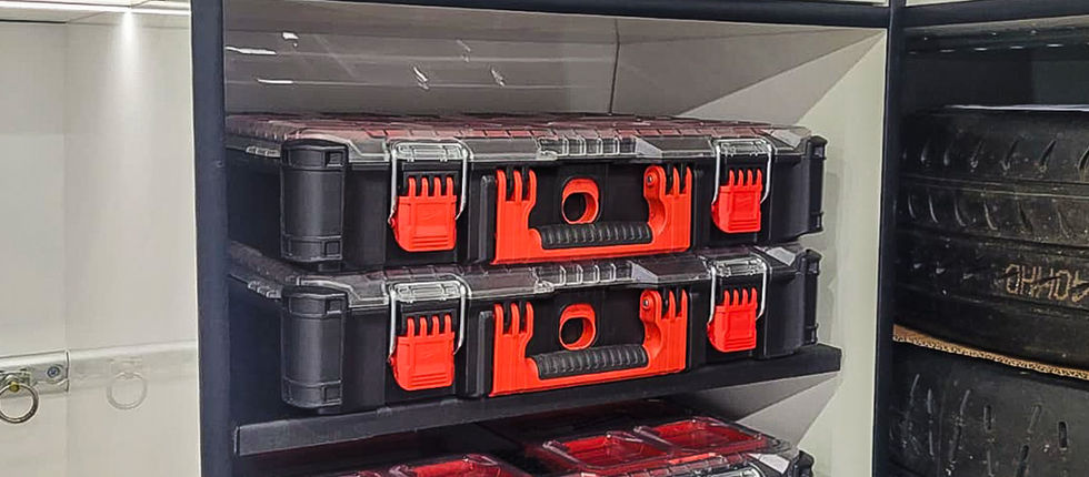 Integrated storage installation combining dedicated tool cases, removable equipment crates and overhead cabinetry alongside the tyre storage system. Every available section of the rear compartment has been considered, creating an organised mobile workshop that brings tools, spares and equipment together within one purpose-built SC Sporthomes conversion.