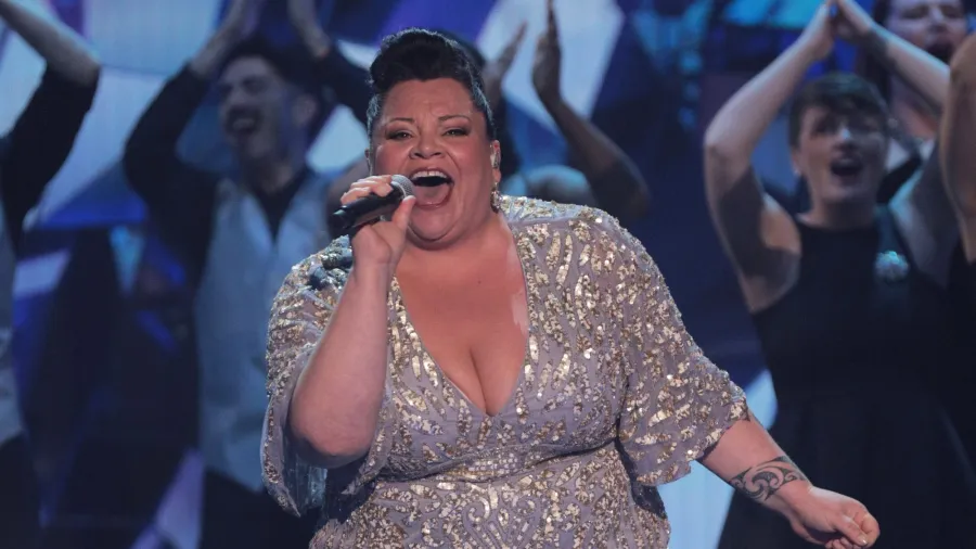 Keala Settle singing in a long gown on stage