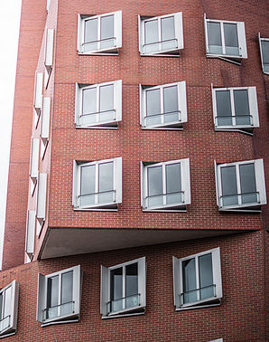 Part of the famous Gehry building in Dusseldorf with sun behind it.jpg