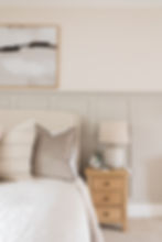 Neutral high-end bedroom with panelling and custom upholstered headboard in a Hampshire home.