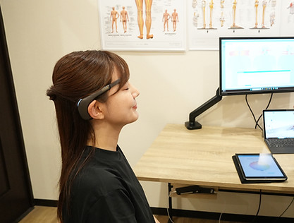 自律神経を調整する機材をつけている女性の画像