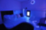  Espace sensoriel à dominante bleue avec éclairages interactifs, coussins et fibres optiques pour un environnement relaxant.