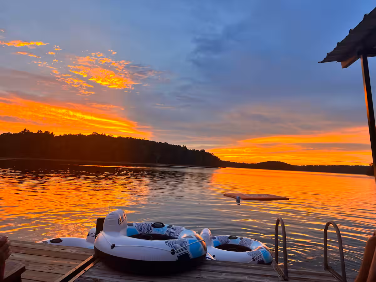 Lake Hartwell, Georgia at sundown from a dock with inflatable tubes floating in the calm waters.