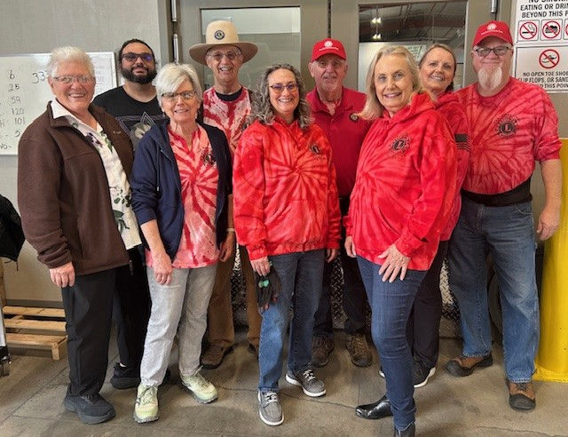 A group of people wearing red shirts smiling at the camera