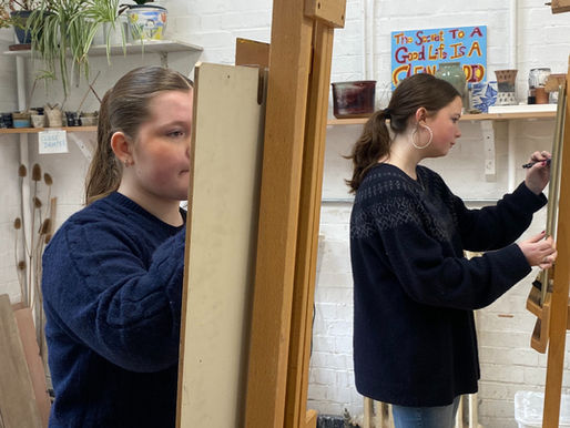 Two Teenagers stood drawing at easels 