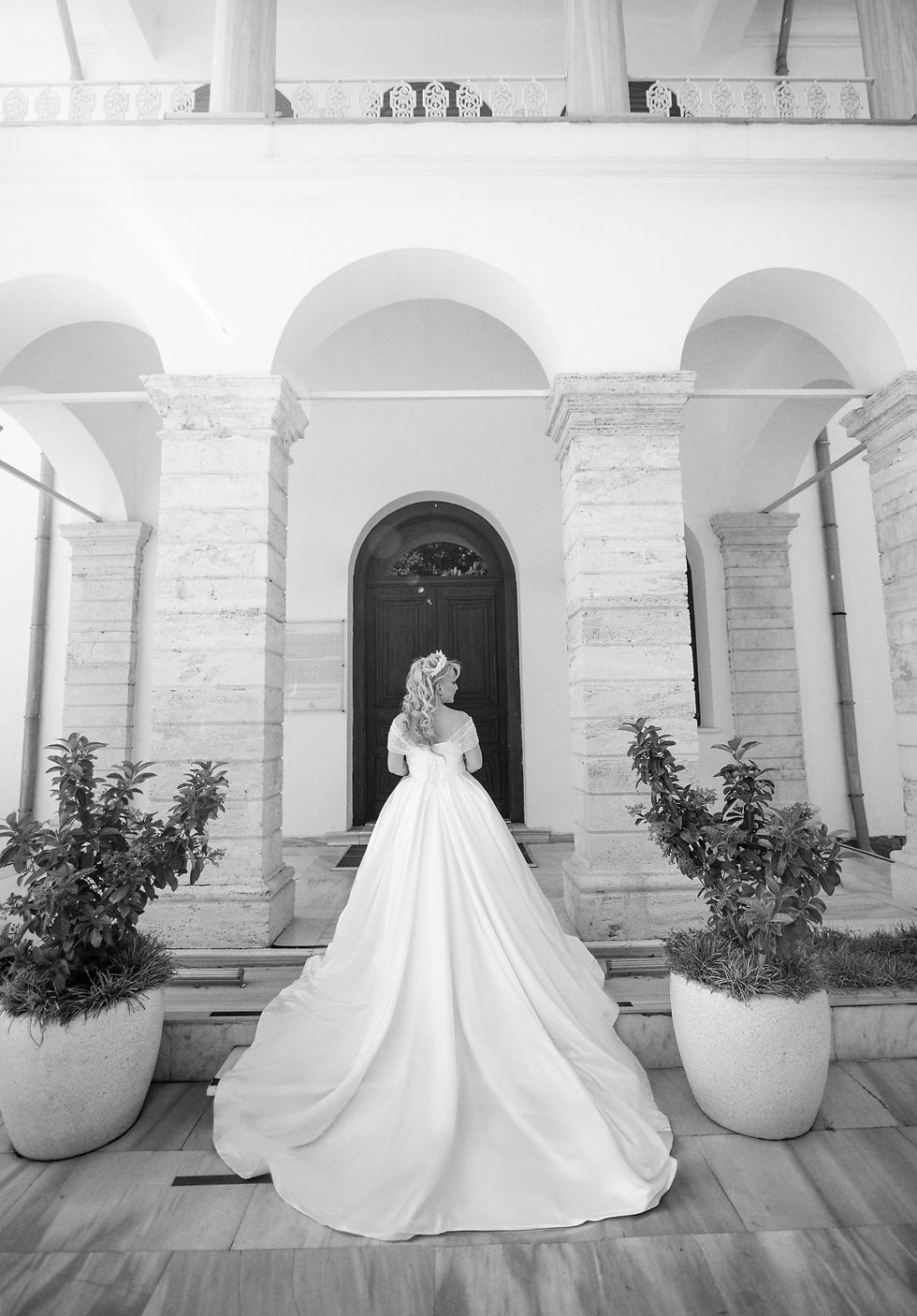 Emirgan Korusu’nun tarihi kapısı önünde uzun kuyruklu gelinliğini sergileyen gelin fotoğrafı