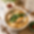 Bowl of noodle soup with dumplings, greens and chopsticks on a table; sign reads AUTHENTIC ASIAN FLAVOURS MADE SIMPLE.