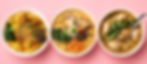 Three bowls of Asian noodle soups and noodles on a pink background, topped with greens, mushrooms, dumplings, and herbs.